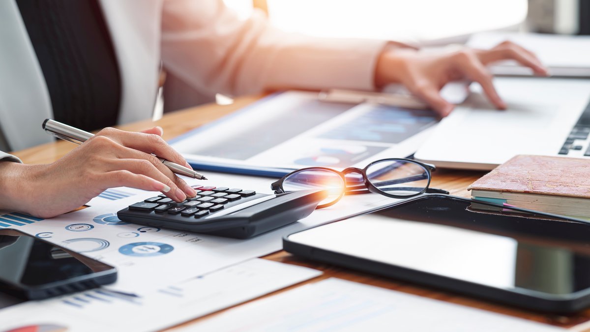 Kalkulation Eine Frau tippt auf dem Taschenrechner