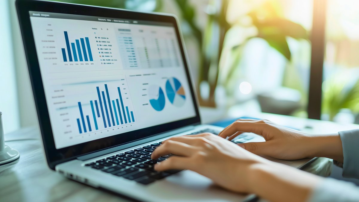 Laptop mit Dashboard Das Bild zeigt einen Laptop mit einem aufwändigen Dashboard und zwei Händen, die auf der Tastatur des Laptops tippen.